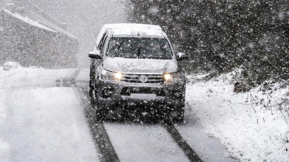 Pick up truck drives in heavy snow