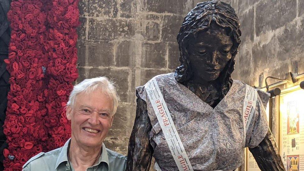 Artist Rodney Munday standing by his sculpture of the virgin Mary