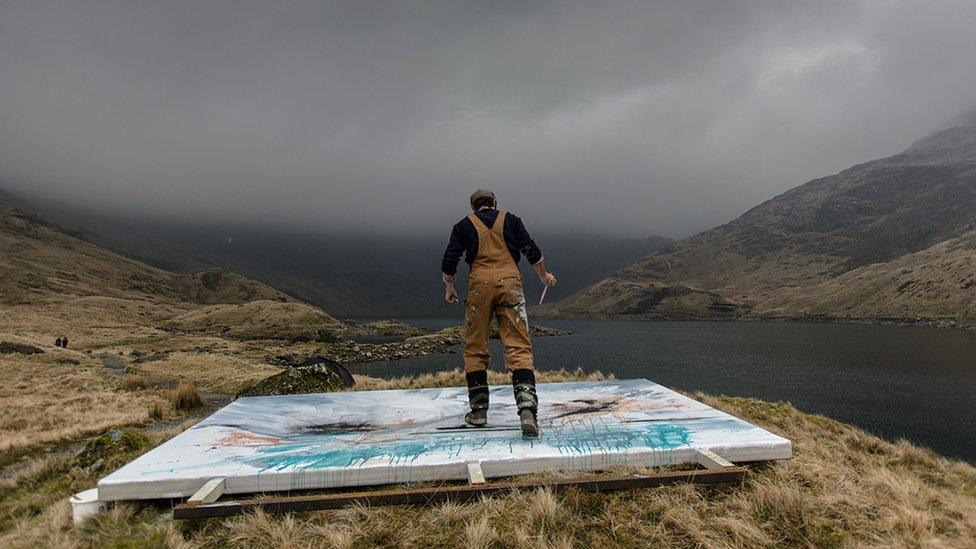 Garratt standing on panel while painting at Llyn Llydaw