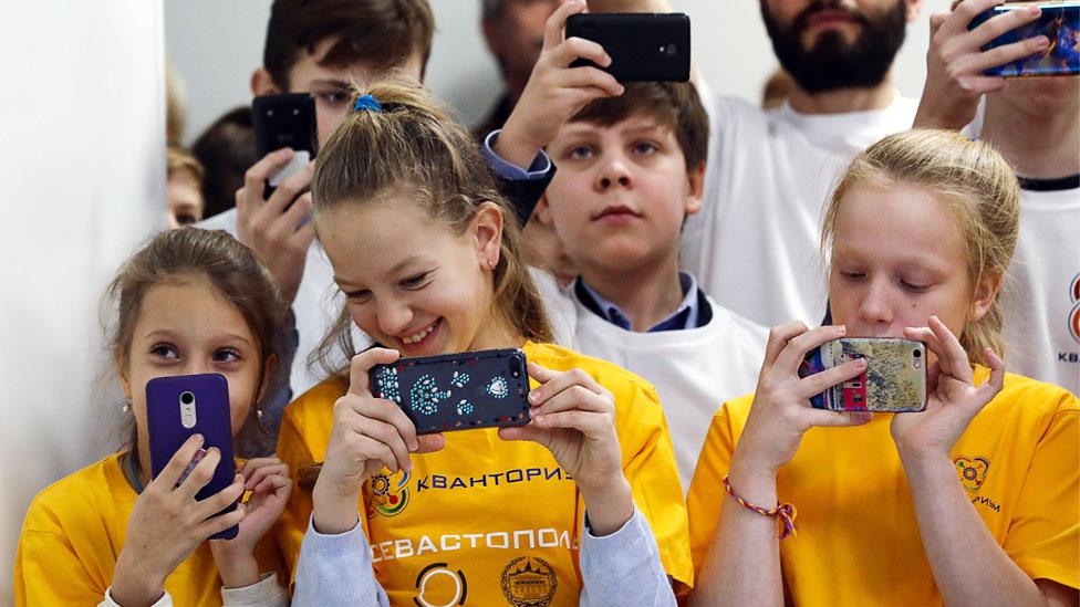 Russian children using mobiles in a science park