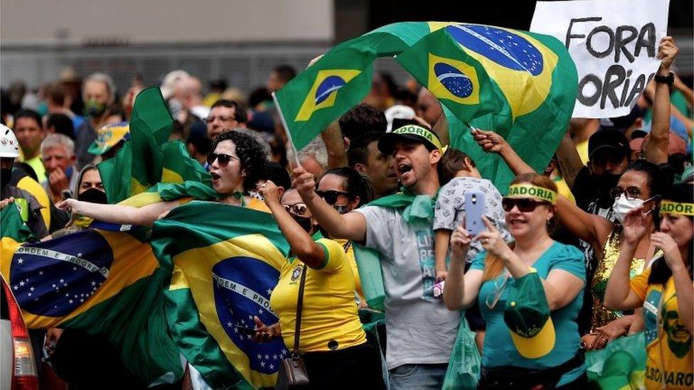 Demonstrators protest against the closure of businesses due to the pandemic in Sao Paulo, Brazil, 14 March 2021.