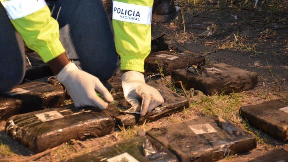 An officer opens one of the parcels found on the bus