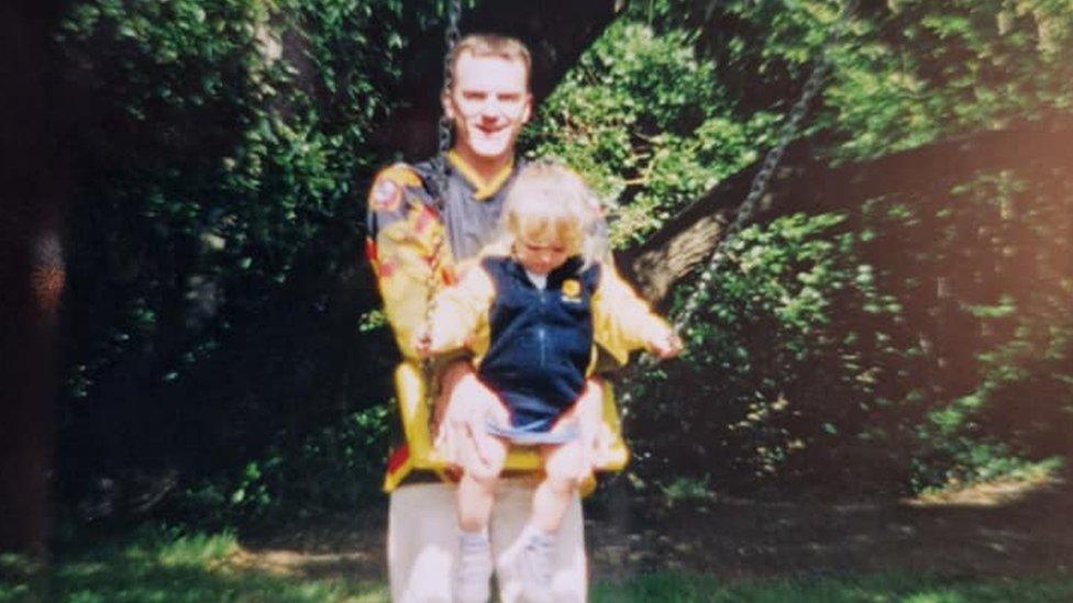 Andy Buchan wearing his Nottingham Panthers jersey and pushing Sophie on the swing as a child