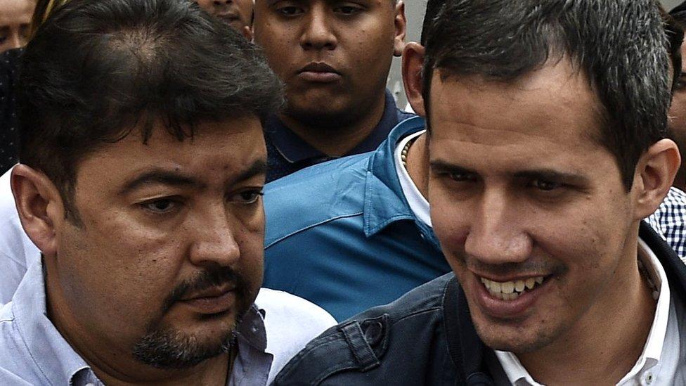 Venezuelan opposition leader and self-declared acting president Juan Guaidó (R), greets supporters, next to his Chief of Staff Roberto Marrero