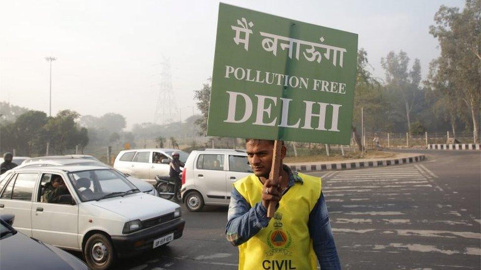 Indian civil defence volunteers hold placards reading: "I will make the Delhi pollution free", at a traffic light during the first day of the implementation of the odd-even scheme for the vehicles in New Delhi, India, 01 January 2016