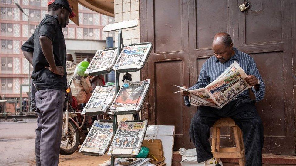 Men reading newspapers at a stall in Kampala, Uganda - 15 January 2021