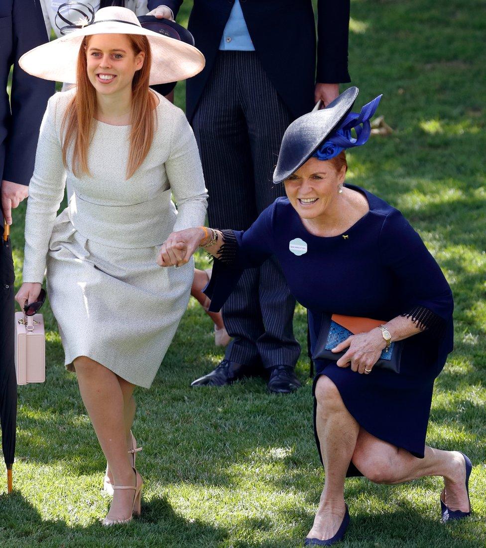 Princess Beatrice and Sarah, Duchess of York curtsy to Queen Elizabeth II as she and her guests pass by in horse drawn carriages at Ascot Racecourse