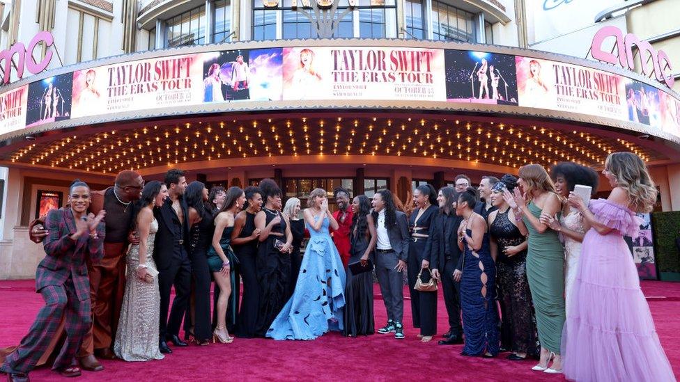 Swift poses with dancers and band members from her tour.