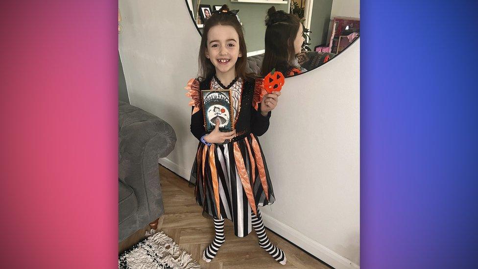 a girl wearing a gothic looking costume with stripey tights