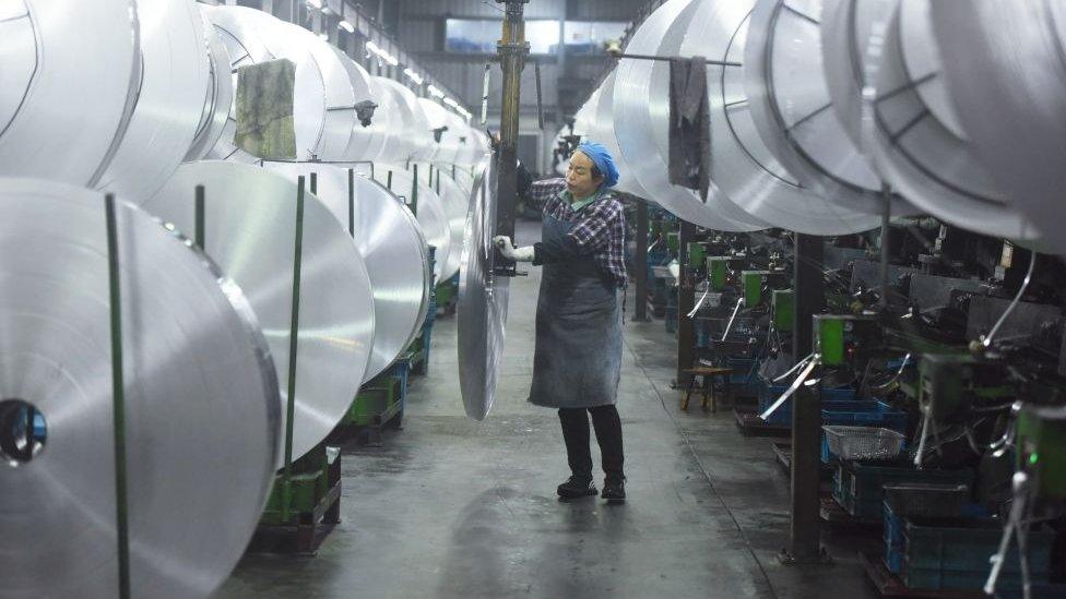 An employee handles aluminium material in Hangzhou, Zhejiang Province of China.