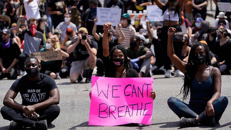 Protesters sit at an intersection during demonstrations following the recent death of George Floyd in Los Angeles, California