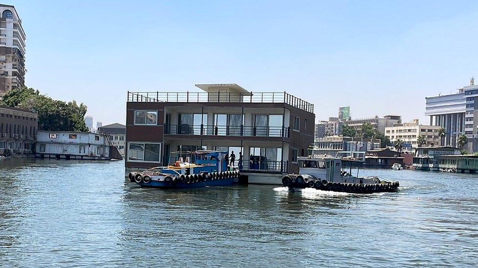 A houseboat is towed away by Egyptian authorities on 28 June 2022