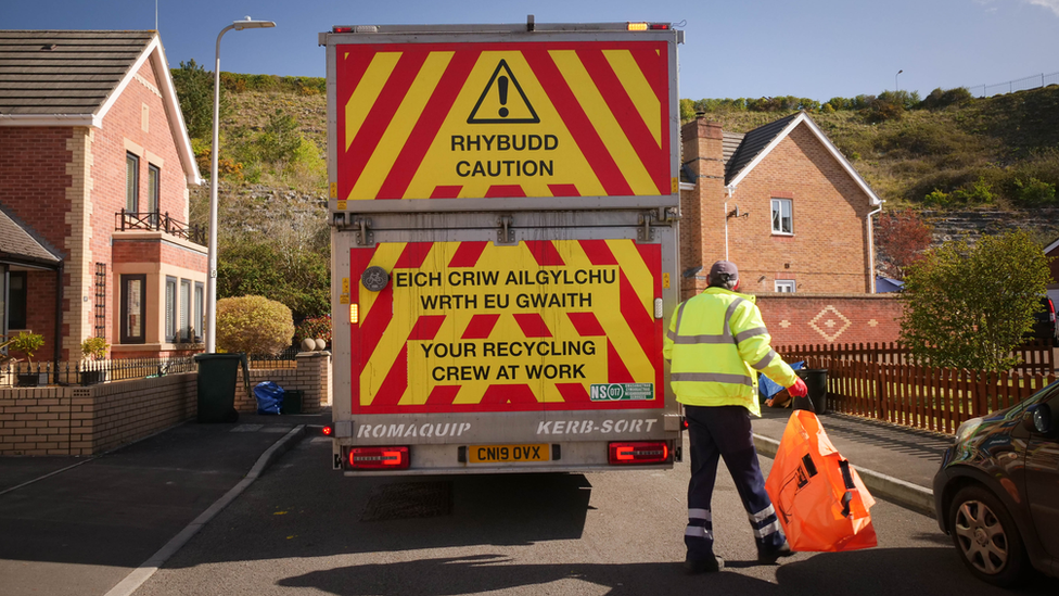 Council staff loading a recycling wagon