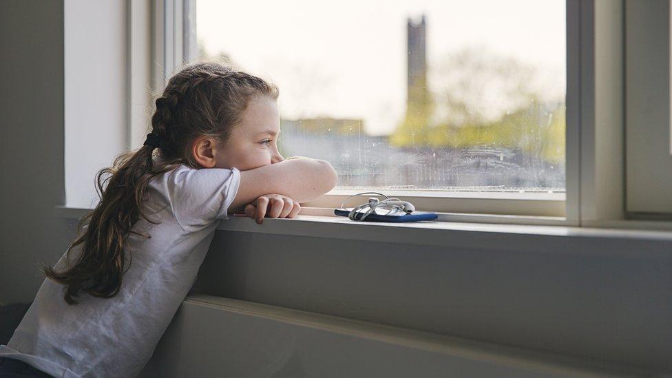 Girl looks out window