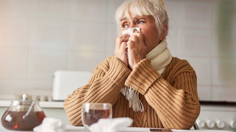 Woman drinking hot tea to relieve a sore throat