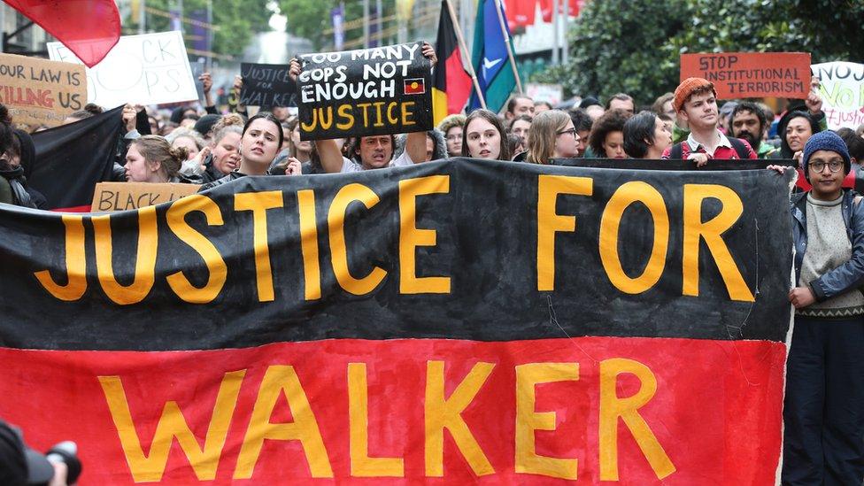 Supporters of Mr Kumanjayi Walker protest in Melbourne carrying a flag which reads "Justice for Walker"