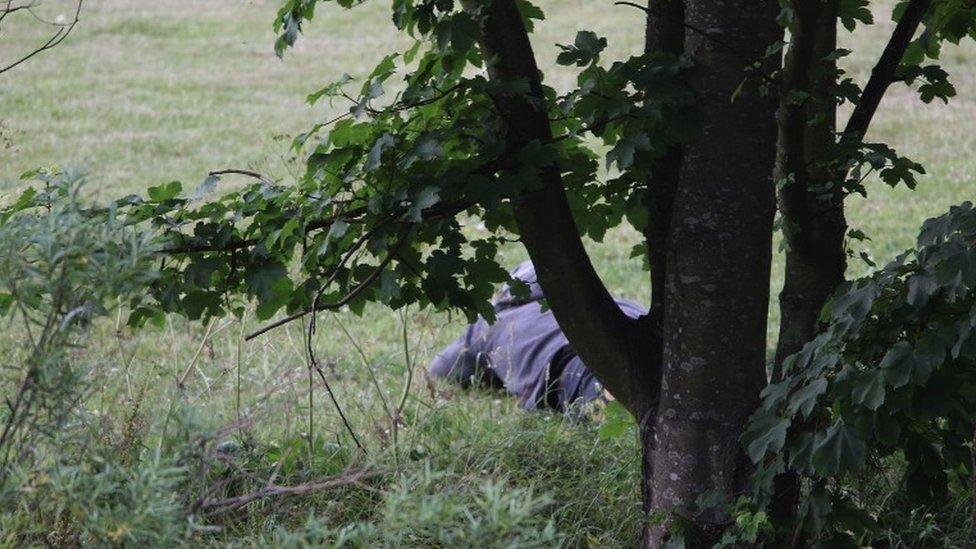 Raoul Moat lying in grass in Rothbury in July 2010