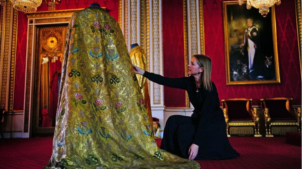 Caroline de Guitaut, deputy surveyor of the King's Works of Art for the Royal Collection Trust, adjusts the Imperial Mantle