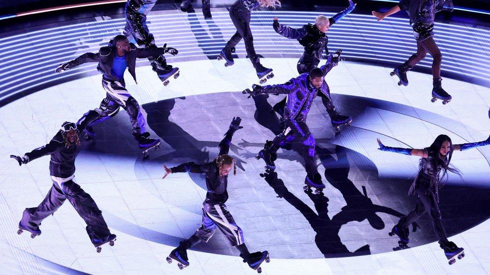 Usher and dancers wearing roller skates