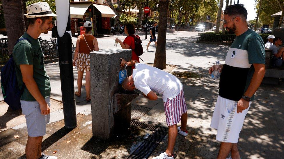 People queue for a public tap in Seville