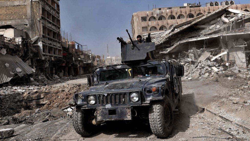 Iraqi forces patrol a street in western Mosul (8 March 2017)