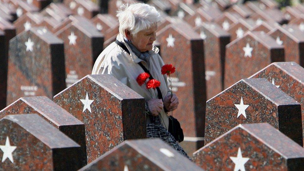 A woman walks past graves of soldiers killed during WW2 at a cemetery in central Moscow (8 May 2006)