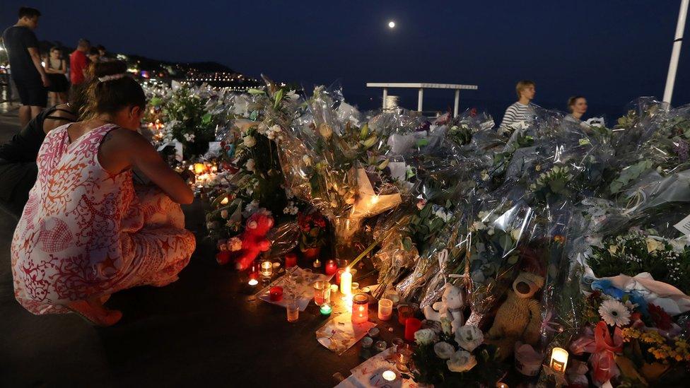 People light candles at a makeshift memorial on the Promenade des Anglais in Nice on July 19, 2016