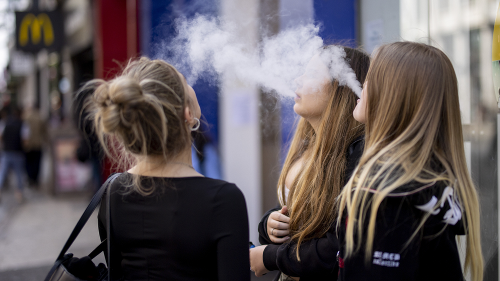 Three young women vaping