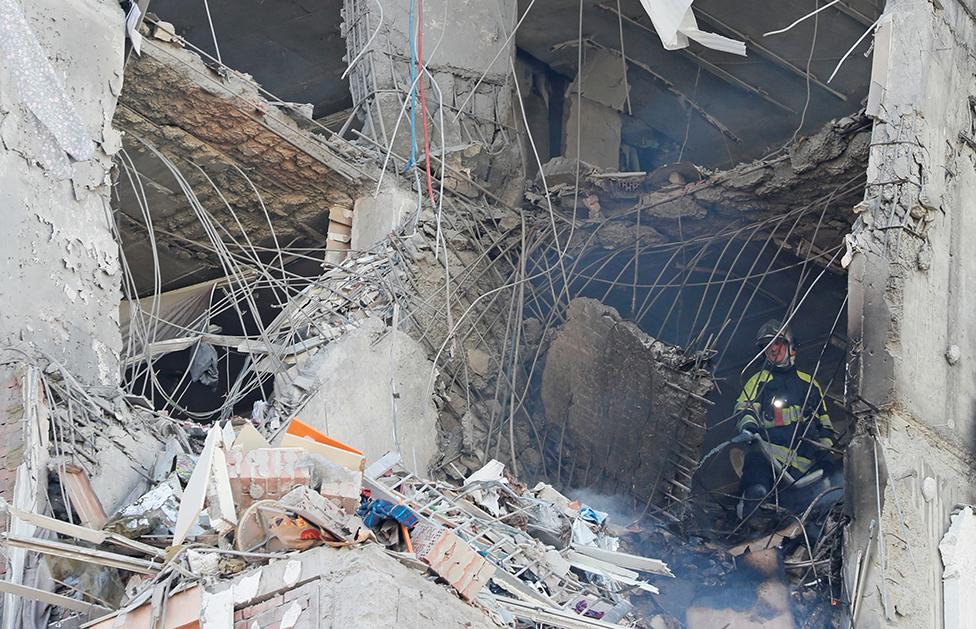 A firefighter works inside an apartment building damaged by recent shelling in Kyiv, Ukraine February 26, 2022