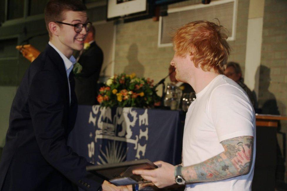 Tom Turner being presented with his award by Ed Sheeran