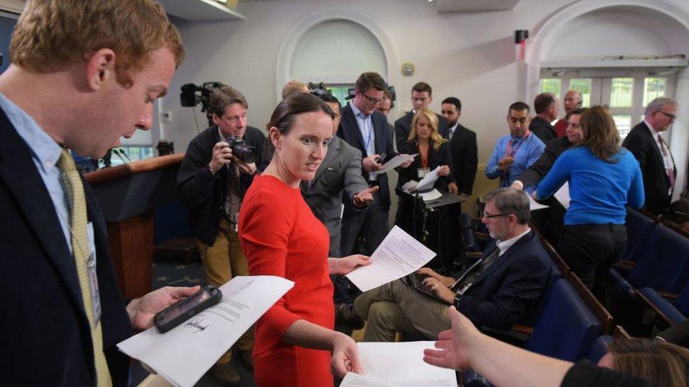 Deputy Press Secretary Lyndsey Walters hands out documents to reporters in the White House, advising them that there will be no further on camera statements, after US President Donald Trump sacked FBI Director James Comey on May 9, 2017