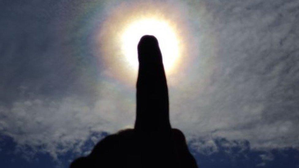 A colourful corona, much smaller than a halo (hence the finger to give perspective) and caused by water not ice, taken during lockdown in April