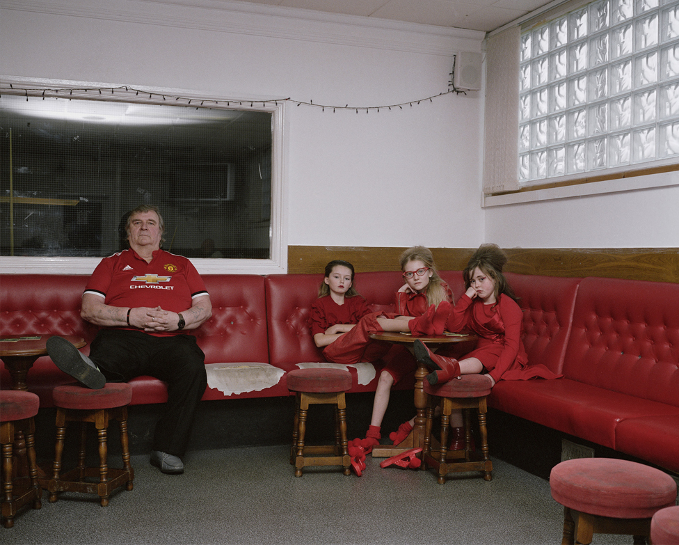 Adult and three children sat in bar