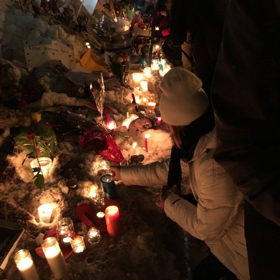 A woman places candles at the vigil outside the mosque