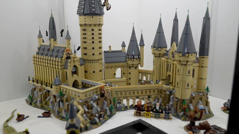 A Lego construct of the Hogwarts castle, complete with yellow bricks and characters outside.