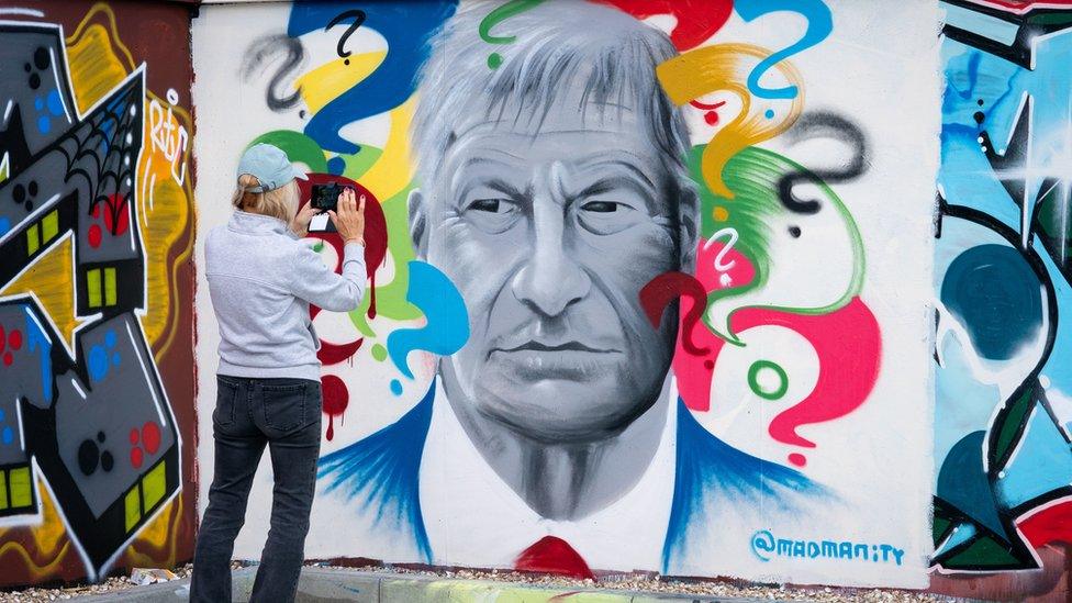 A person takes a photograph of "Why", a mural of Sir David Amess by local Artist Madmanity, at a skate park in Leigh-on-Sea, Essex. The Conservative MP Sir David Amess died after he was stabbed several times at a constituency surgery on Friday.