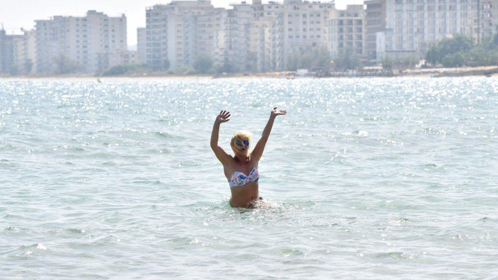 A woman is seen on the sea inside an area fenced off by the Turkish military since 1974 in the abandoned coastal area of Varosha