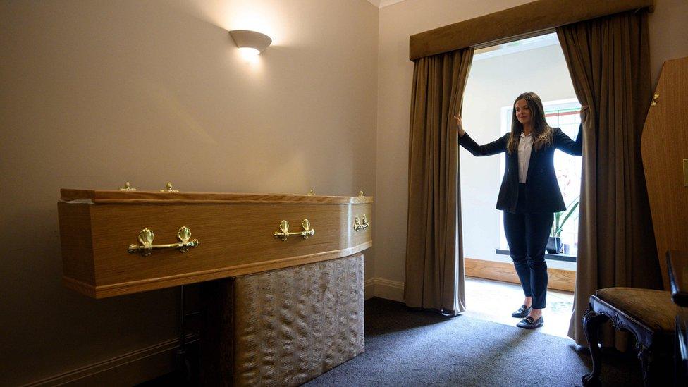 Funeral director with a coffin