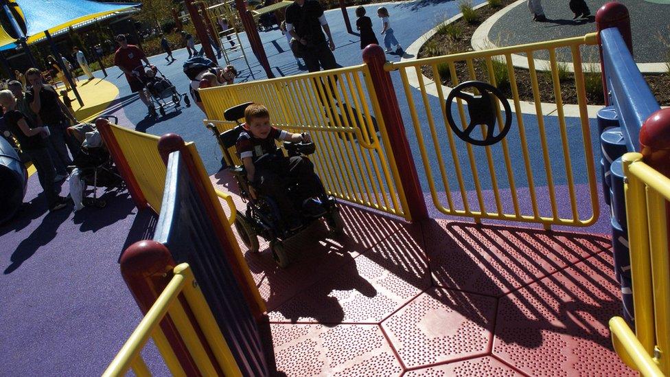 Child in wheelchair plays on an accessible playground structure