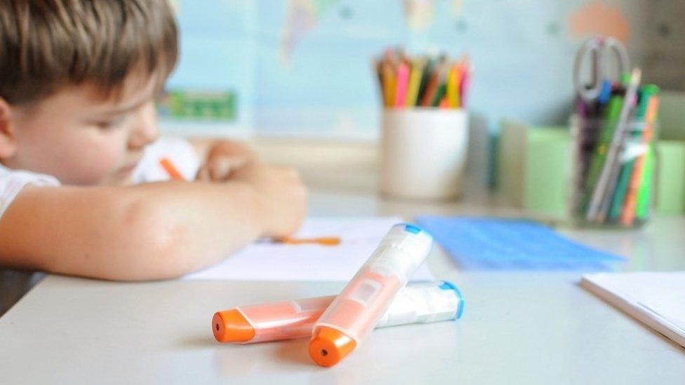 Young child with an anaphylaxis injector pen