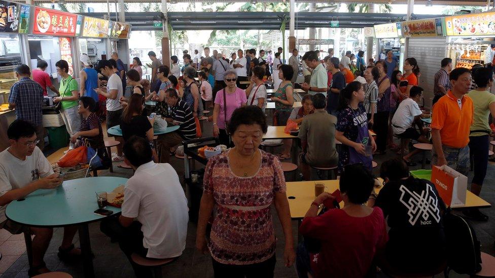 People queue for food at a hawker centre