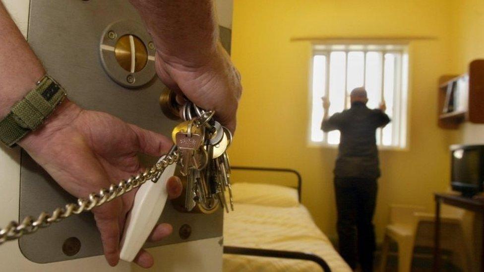 prison guard locking prison cell