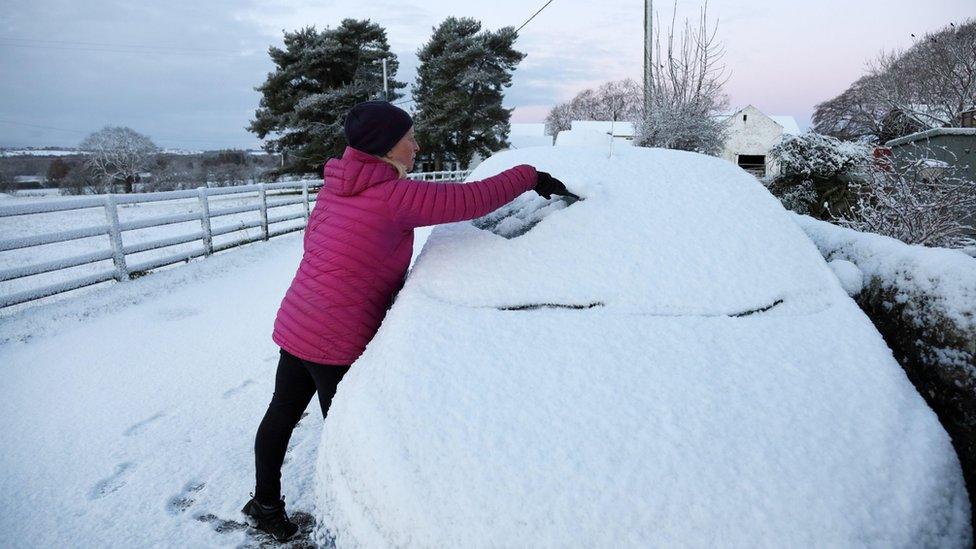 Woman tries to scrape car windscreen in Teesdale, County Durham