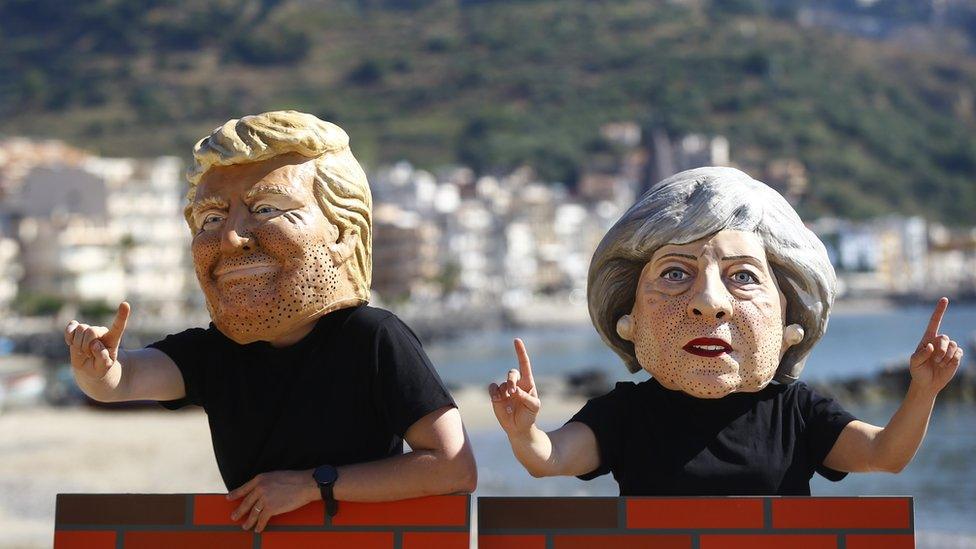 Protesters wear May and Trump masks