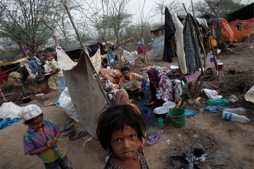 A family, who says they belong to the Burmese Rohingya Community from Myanmar, eats their breakfast at a makeshift shelter in a camp in New Delhi, India, May 14, 2012.