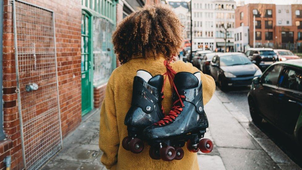 Woman carrying roller skates