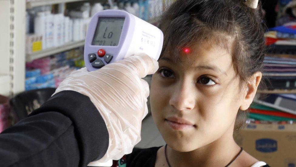 child has temperature taken at a supermarket