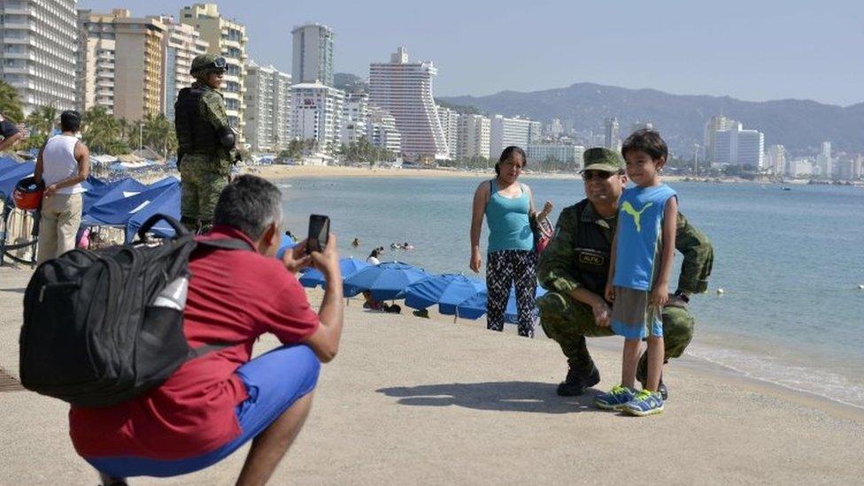 A boy poses for a picture with a Mexican Army soldier patrolling along Acapulco"s coastline, in Guerrero state, Mexico on December 5, 2017.