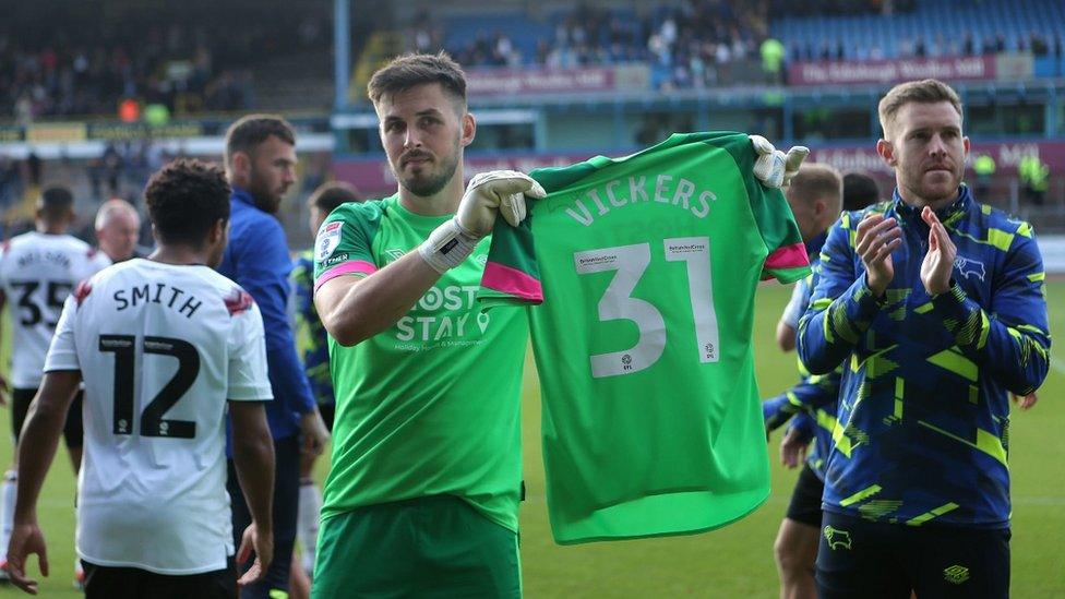 Josh Vickers shirt held by team mates