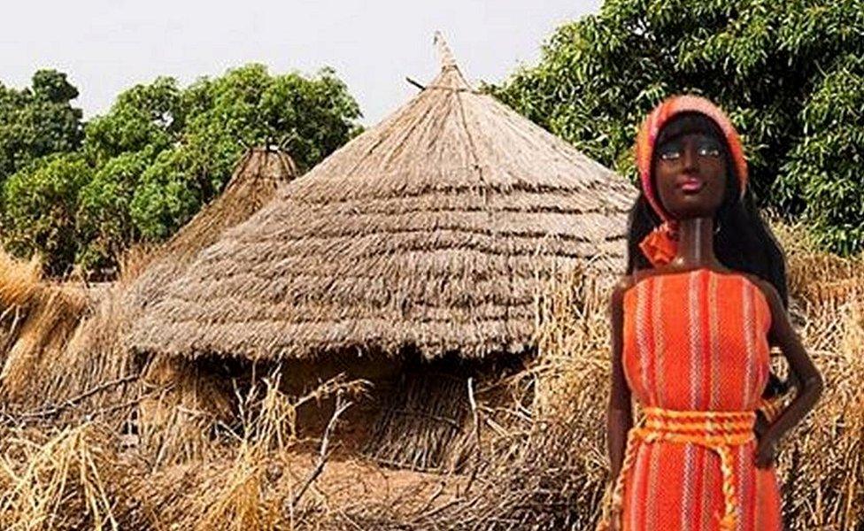 Barbie doll in front of a hut